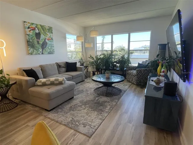 a living room with furniture fireplace and a large window