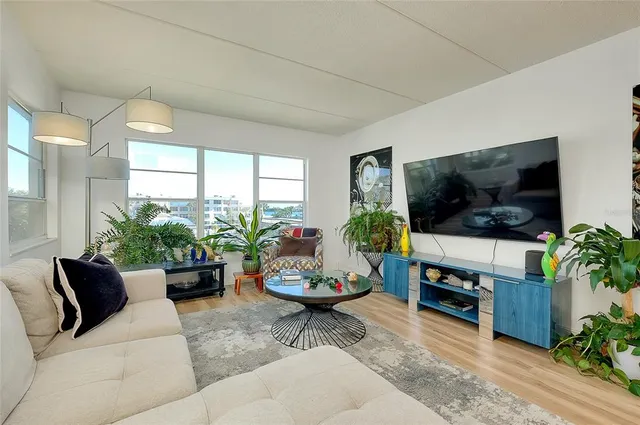 a living room with furniture kitchen and a potted plant