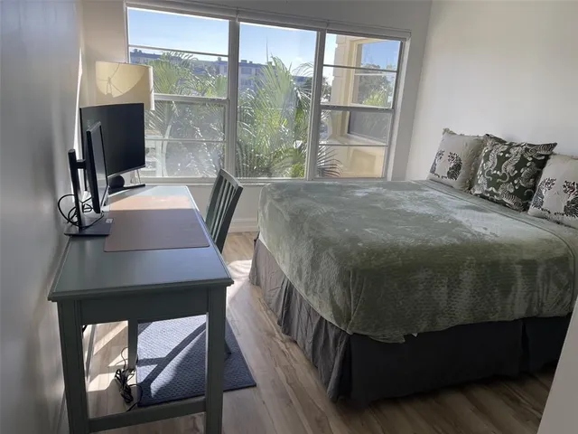 a bedroom with a bed a mirror and a window