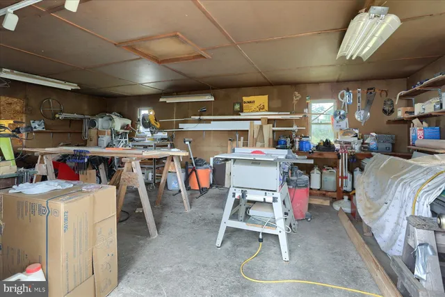 a room with stainless steel appliances kitchen island granite countertop lots of furniture