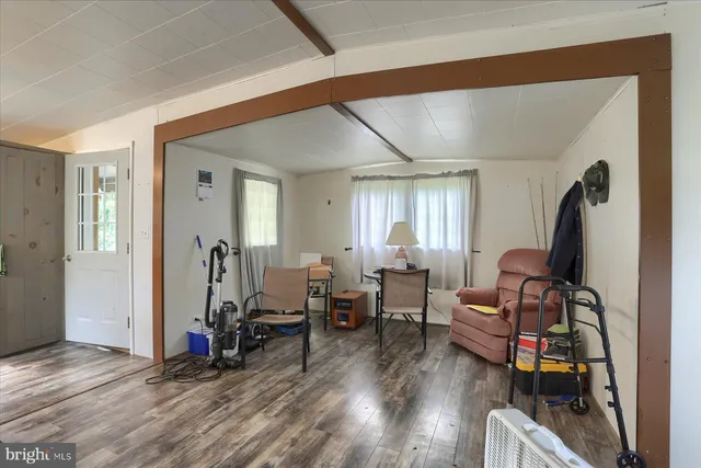 a living room with furniture a wooden floor and gym equipment