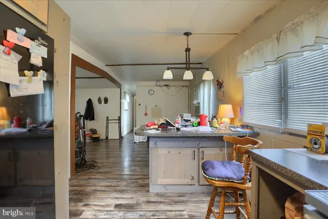 a view of a dining room and livingroom with furniture wooden floor a chandelier