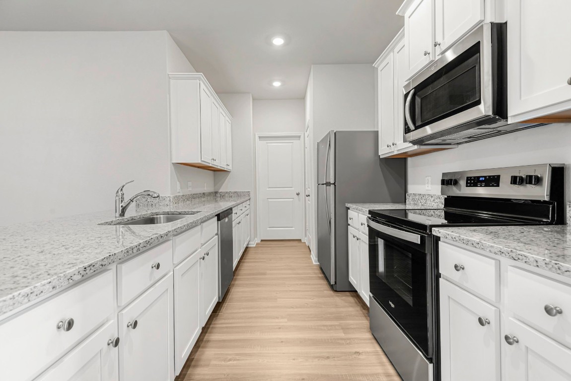 a kitchen with granite countertop a sink and steel appliances