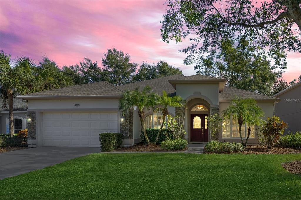3984 Beacon Ridge Way Clermont, FL 34711 - Photo 1 of 1 a front view of a house with a garden and trees