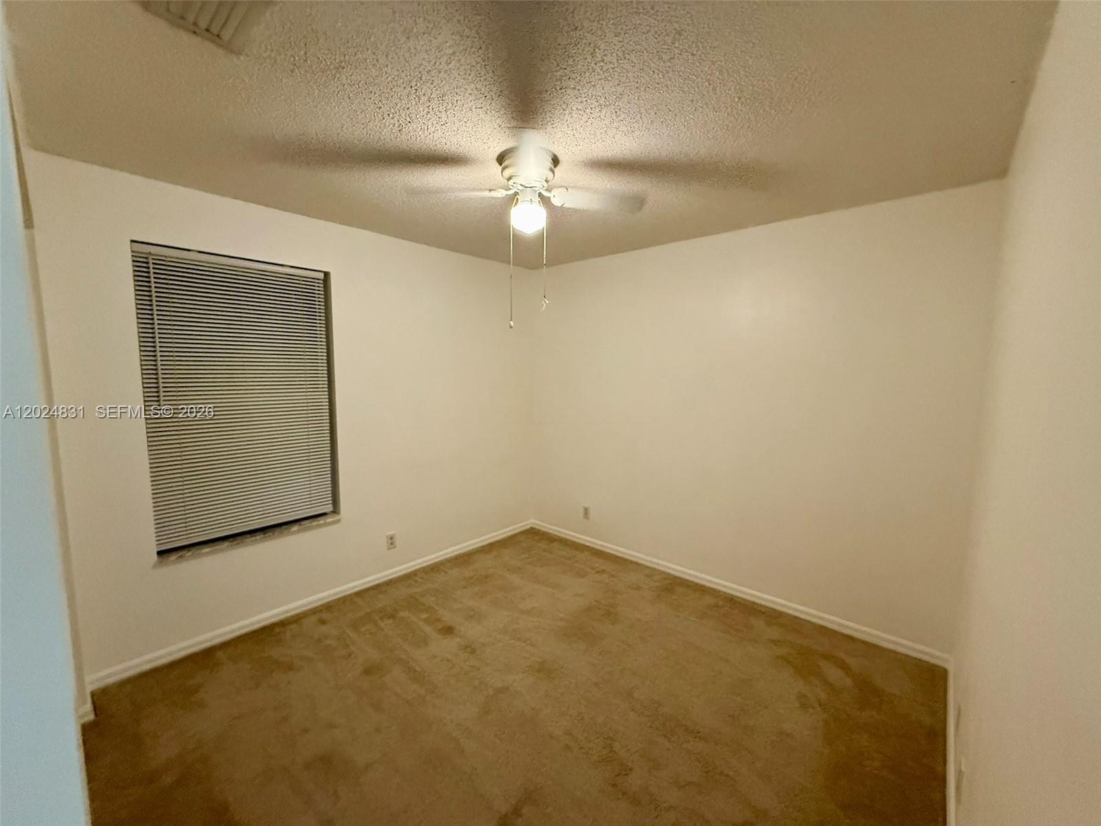 15819 76th Road North Loxahatchee, FL 33470 - Photo 39 of 45 an empty room with a chandelier fan and closet