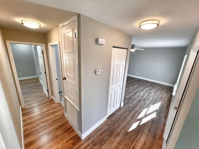 a view of a hallway with wooden floor and staircase