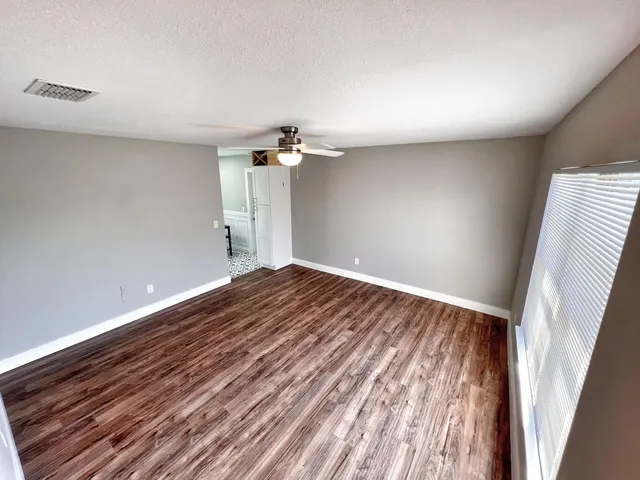a view of empty room with wooden floor