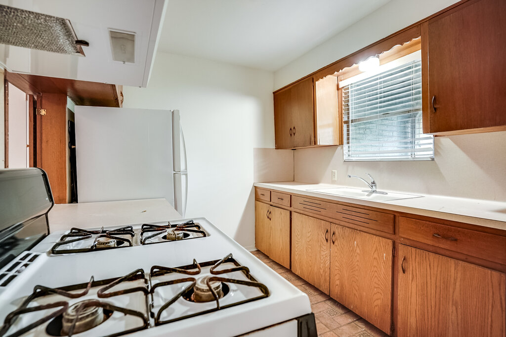 3707 Tom Green Street, Unit 2 Austin, TX 78705 - Photo 4 of 14 Kitchen with white appliances, light countertops, and brown cabinetry