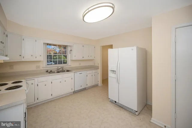 a kitchen with white cabinets and white appliances