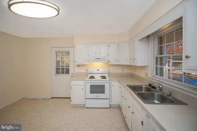 a kitchen with a sink stove and cabinets