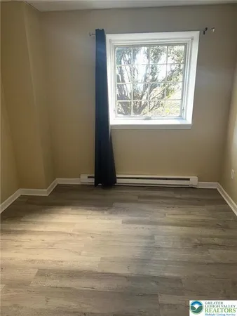 a view of a room with wooden floor and a window