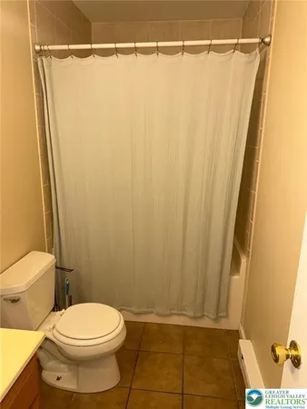 a bathroom with a shower curtain and a toilet