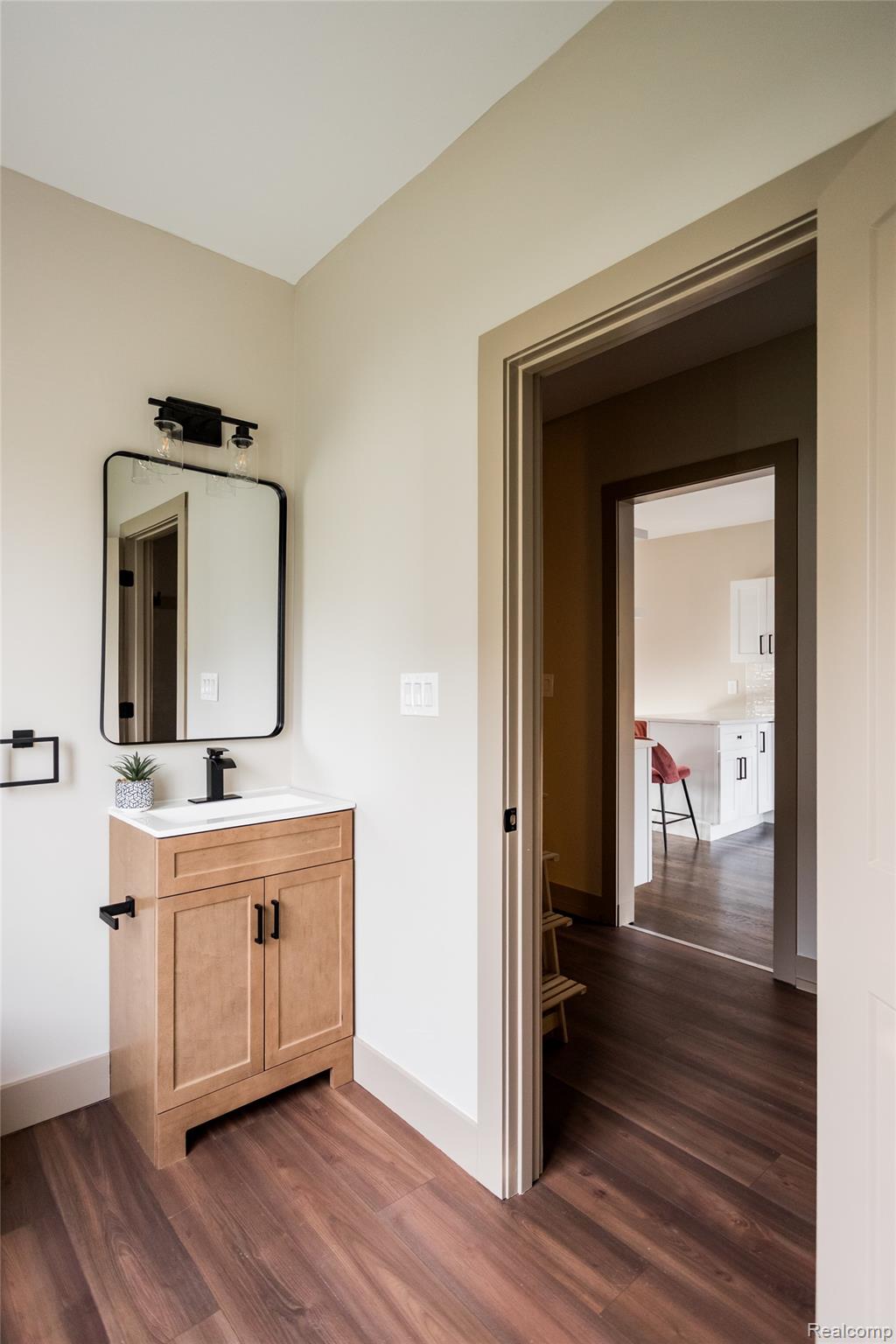 2630 Harding Street Detroit, MI 48214 - Photo 14 of 30 Powder room featuring a single vanity with wood-finish cabinetry, a rectangular basin, and a black faucet