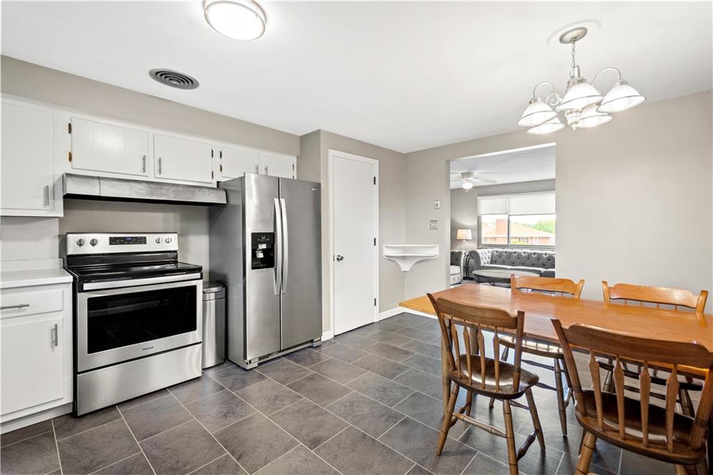 304 Rockfield Road Pittsburgh, PA 15243 - Photo 7 of 25 a kitchen with stainless steel appliances a stove a table and chairs