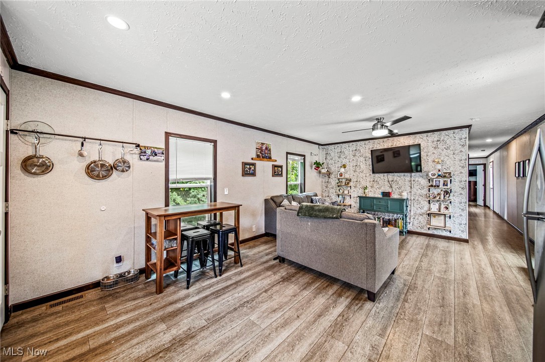 202 West Main Road, Unit LOT 13 Conneaut, OH 44030 - Photo 12 of 23 Living area with wood finished floors, crown molding, a textured ceiling, a ceiling fan, and recessed lighting