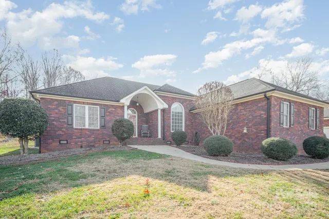 a view of a house with a yard and pathway