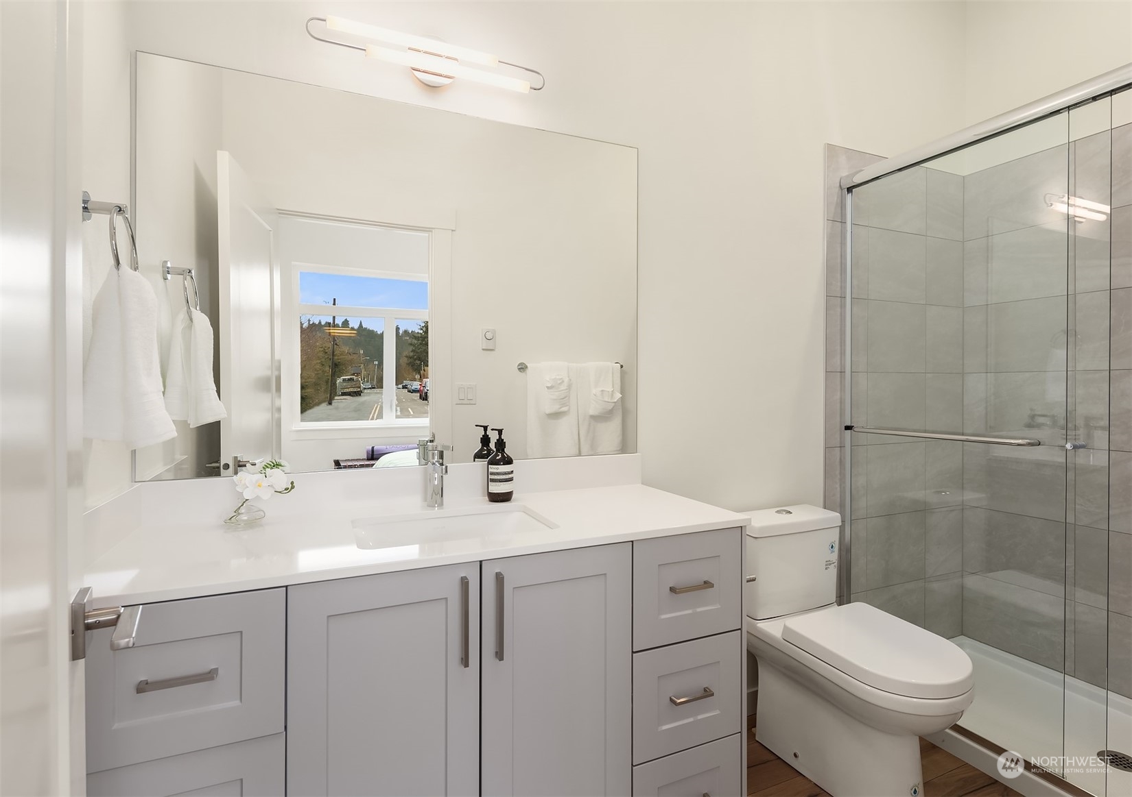 10322 Northeast 185th Street, Unit A Bothell, WA 98011 - Photo 12 of 22 a bathroom with a sink toilet vanity and shower