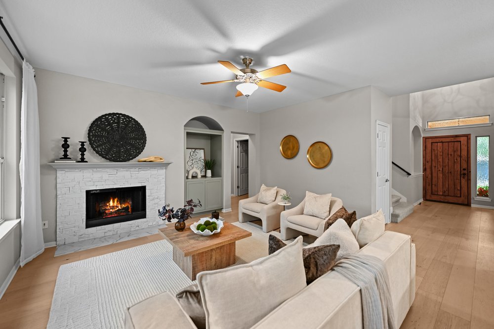 2823 Lantana Ridge Drive Austin, TX 78732 - Photo 6 of 34 a living room with furniture a fireplace and wooden floor