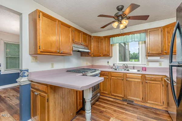 a kitchen with a sink a stove cabinets and a window