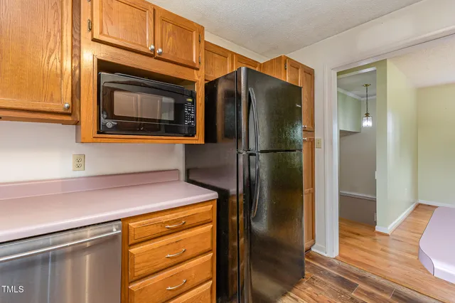 a kitchen with stainless steel appliances granite countertop a refrigerator and a stove top oven