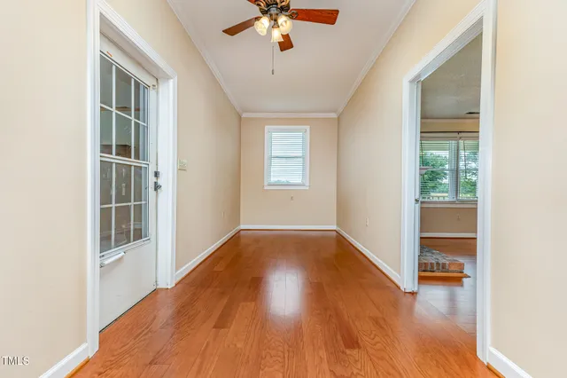 a view of an empty room with window and wooden floor