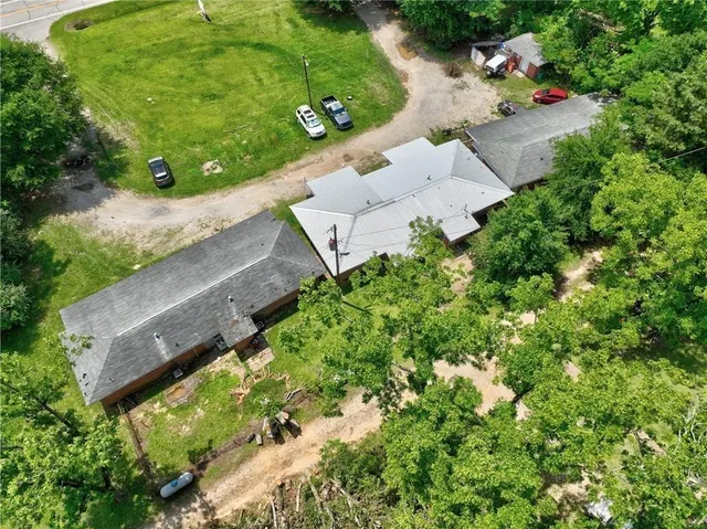 an aerial view of a house with a yard and trees