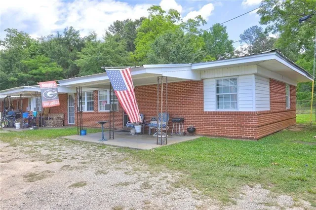 a view of a house with a yard and sitting area