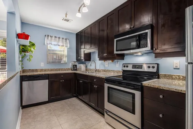 a kitchen with stainless steel appliances granite countertop a stove microwave and sink