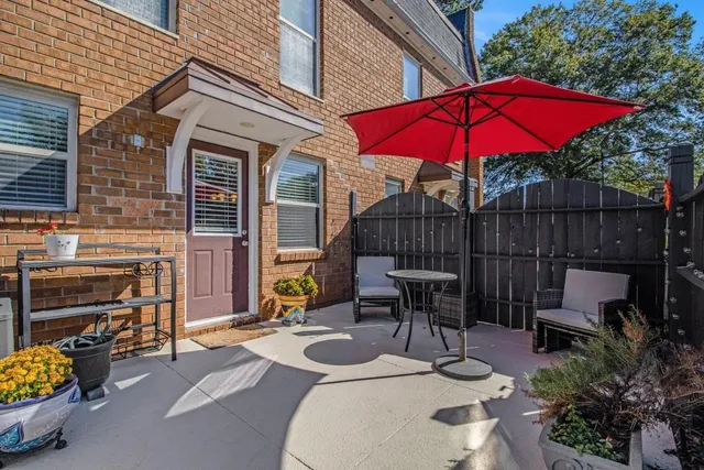 a patio with a table and chairs under an umbrella