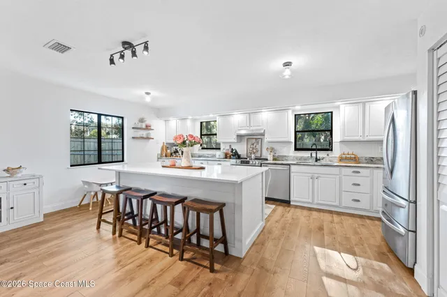 a kitchen with white cabinets and counter space