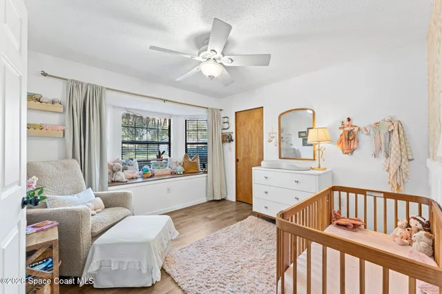 a bedroom with furniture and a large window