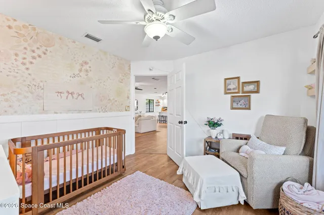 a living room with furniture and a baby crib