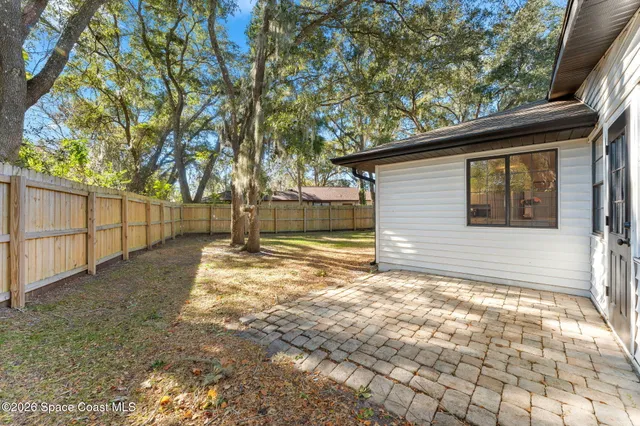 a view of a yard with wooden fence