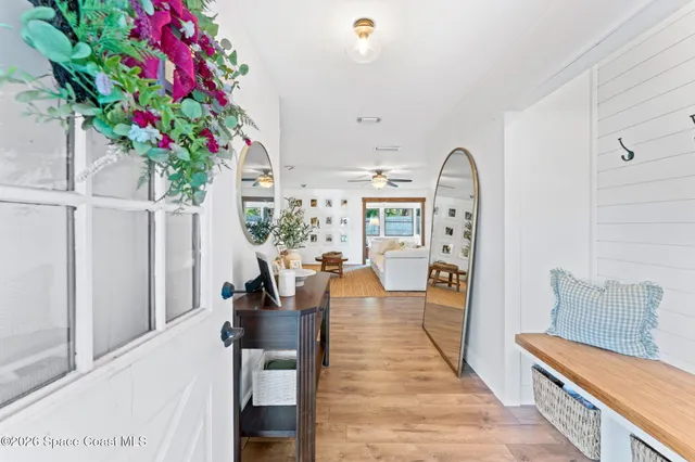 a hallway with a flower pot and wooden floor