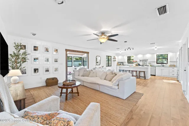 a living room with furniture and view of kitchen