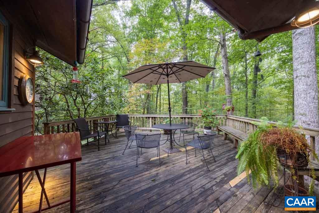 5115 Catterton Road Free Union, VA 22940 - Photo 31 of 44 a view of a patio with table and chairs under an umbrella with a barbeque