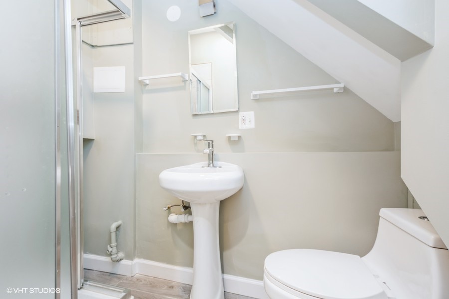 2149 North Lorel Avenue, Unit 2 Chicago, IL 60639 - Photo 5 of 9 a bathroom with a sink mirror toilet and shower