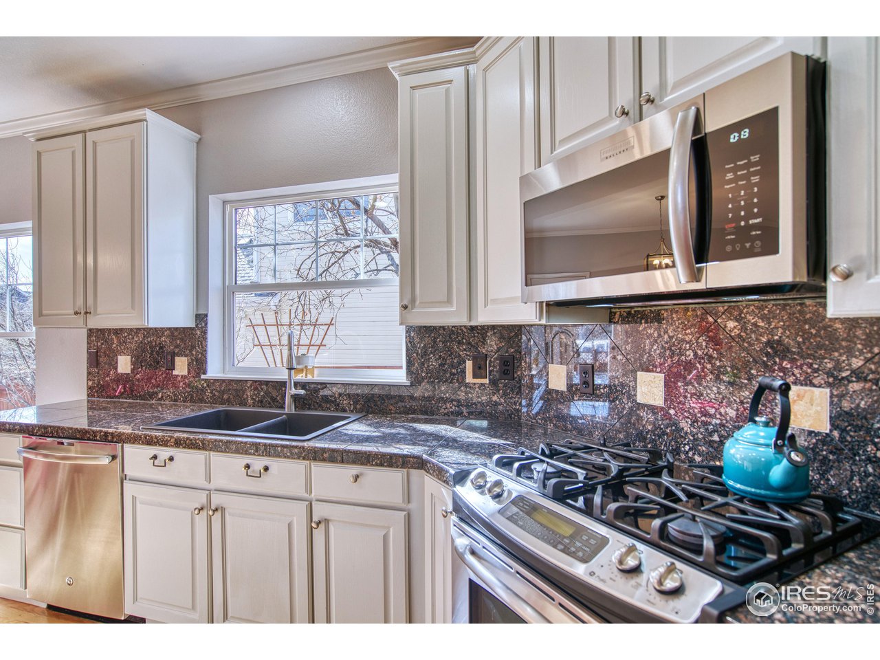 4944 Dakota Boulevard Boulder, CO 80304 - Photo 12 of 40 a kitchen with stainless steel appliances granite countertop a stove a sink and a microwave