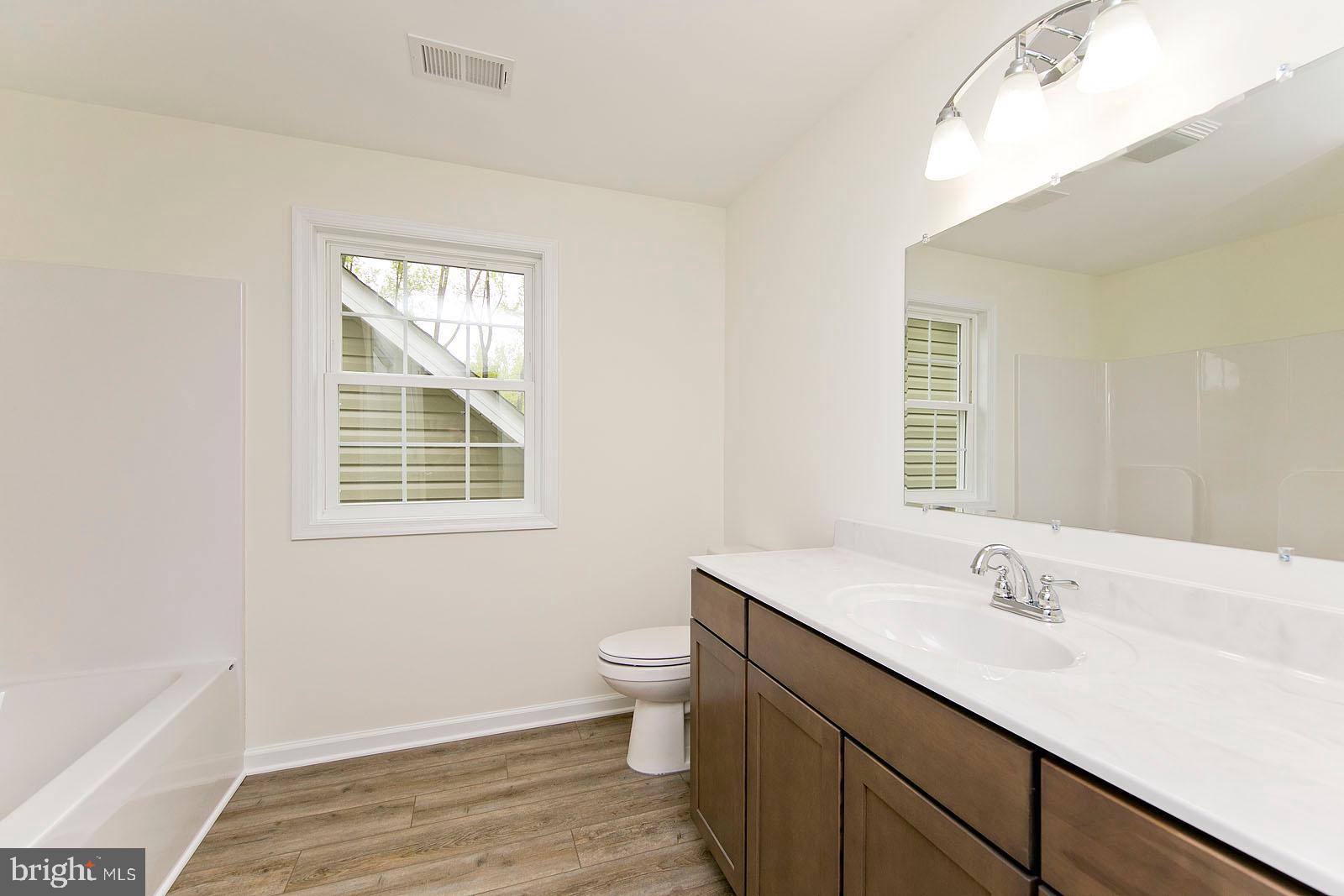 320 Pine Grove Road Bluemont, VA 20135 - Photo 25 of 28 a bathroom with a sink a toilet a mirror and a window