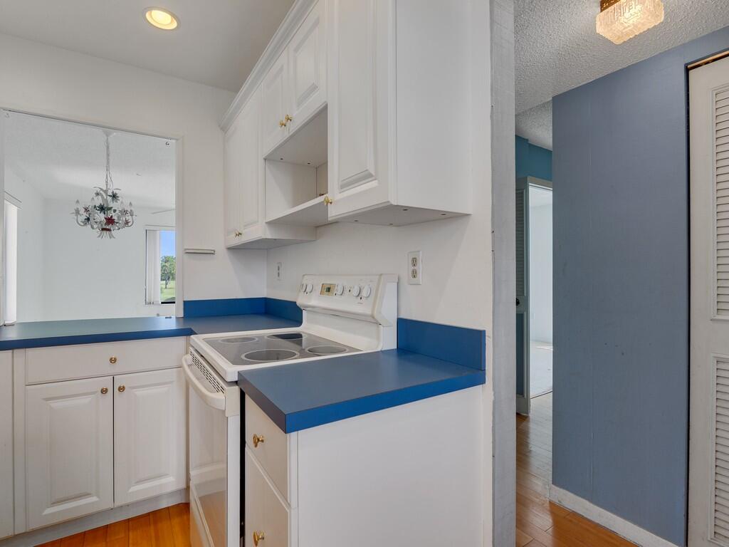 5373 Southeast Miles Grant Road, Unit 208 Stuart, FL 34997 - Photo 2 of 32 a kitchen with cabinets and white appliances