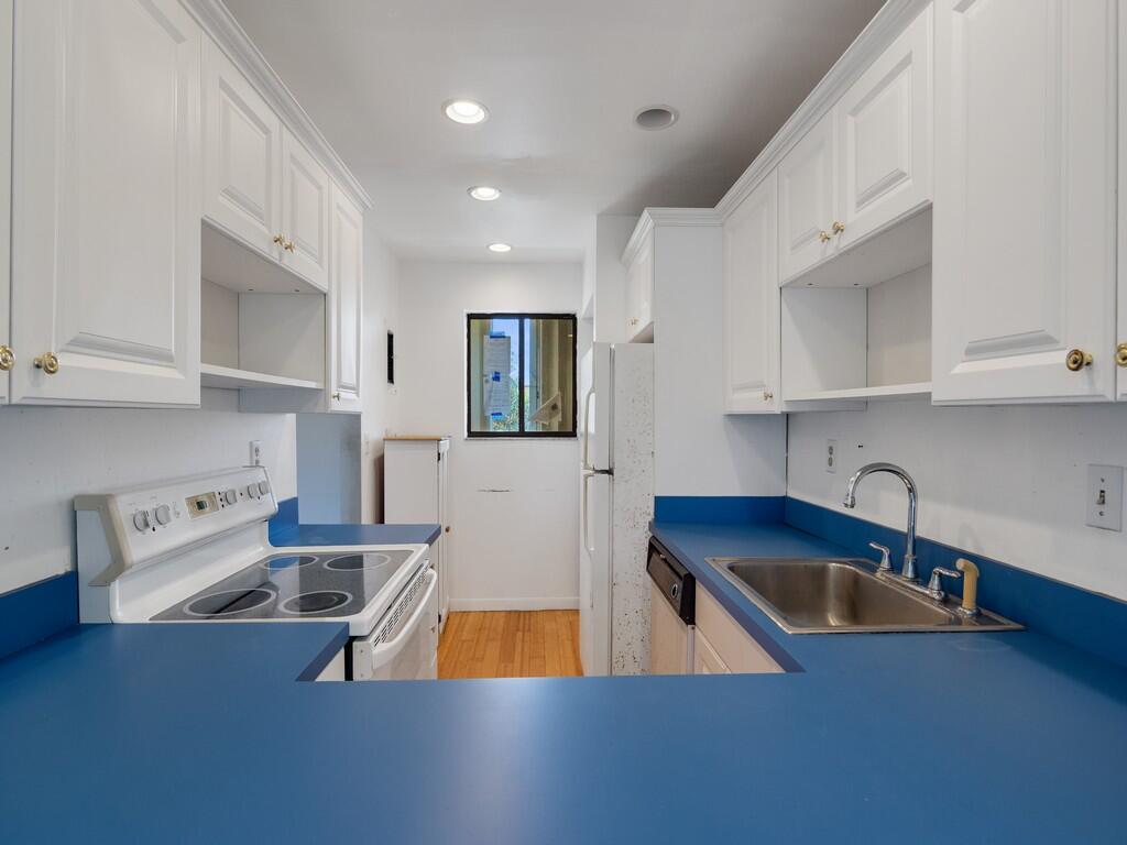 5373 Southeast Miles Grant Road, Unit 208 Stuart, FL 34997 - Photo 3 of 32 a kitchen with stainless steel appliances granite countertop a sink a stove and a refrigerator