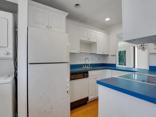 a kitchen with a refrigerator sink and cabinets
