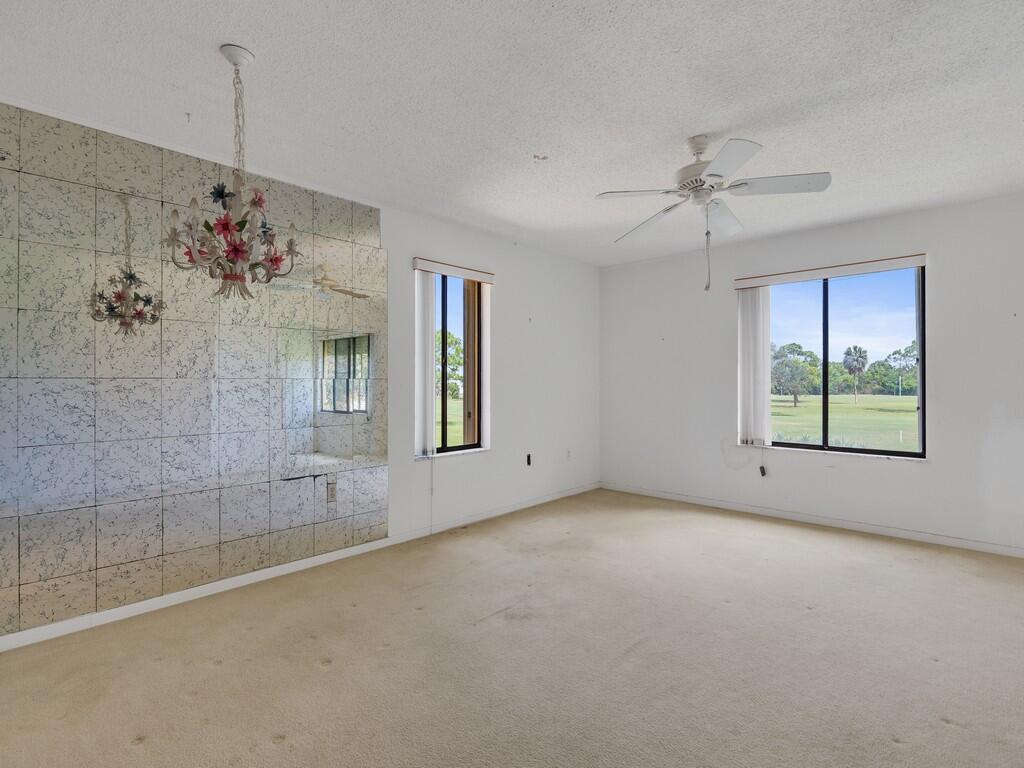 5373 Southeast Miles Grant Road, Unit 208 Stuart, FL 34997 - Photo 6 of 32 a view of a livingroom with a chandelier fan and windows