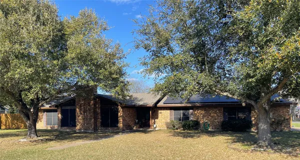 a front view of a house with a tree