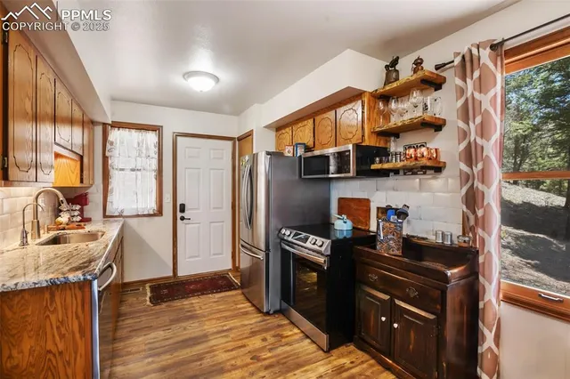 a kitchen with stainless steel appliances granite countertop a refrigerator and a stove top oven