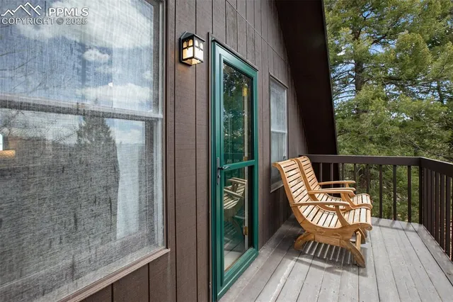 a balcony with wooden floor table and chairs