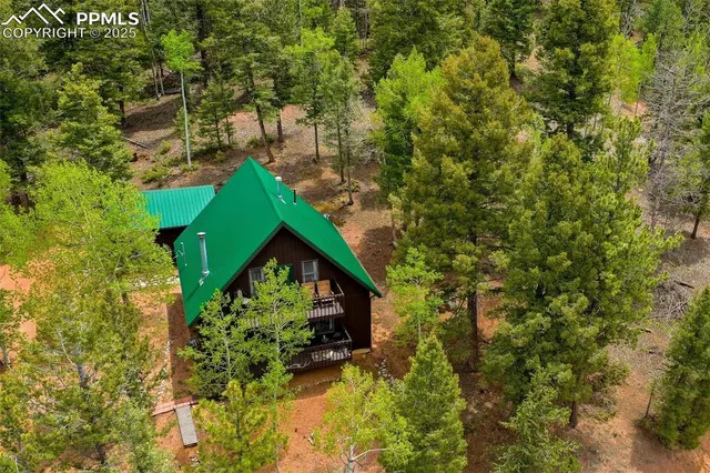 a backyard of a house with table and chairs under an umbrella