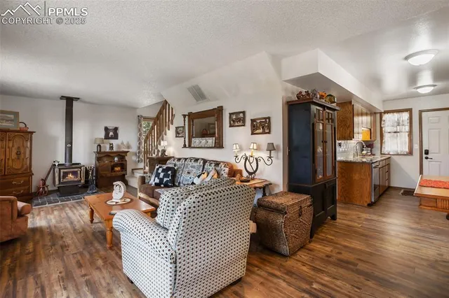 a living room with furniture a flat screen tv and a refrigerator