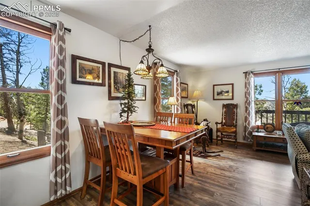 a dining room with furniture a chandelier and wooden floor