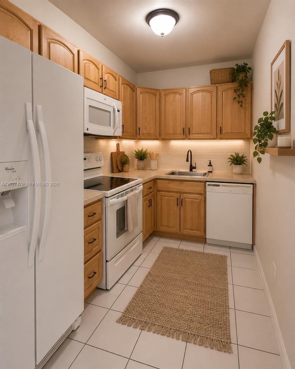 405 South Pine Island Road, Unit 308D Plantation, FL 33324 - Photo 6 of 14 a kitchen with stainless steel appliances granite countertop a sink and a refrigerator